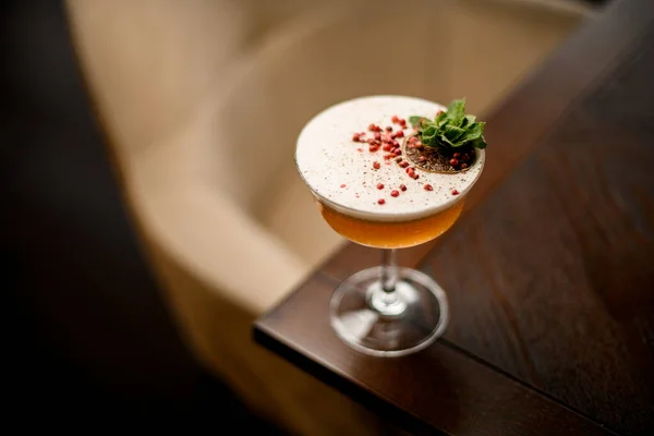 Köstlicher alkoholischer Cocktail im Glas mit Minzzweig, roten Pfefferkörnern und getrockneten Orangenscheiben — Stockfoto