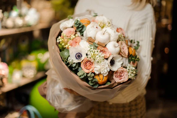 Girl holding a bouquet of white and peach color roses decorated with apples, cinnamon sticks and dried oranges — 스톡 사진