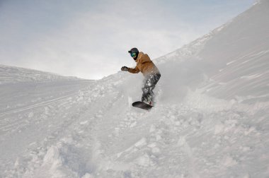 Sakat bir adam tek eliyle snowboard yapıyor.