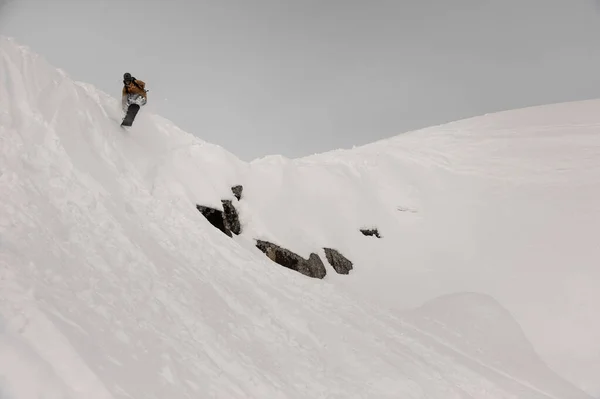 Engelli snowboardcu beyaz kar kaplı tepeden atlıyor — Stok fotoğraf