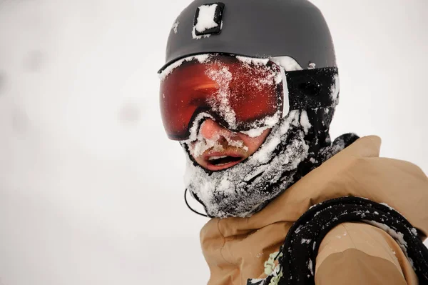 Snowboarder em pé na encosta nos óculos de proteção olhando para a câmera — Fotografia de Stock