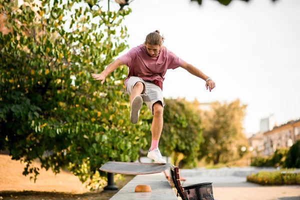 Chłopiec skaczący po tablicy balansowej na betonowej granicy w parku — Zdjęcie stockowe