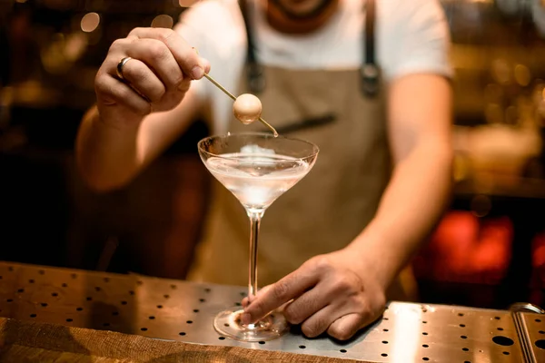 Чоловік бармен додає білий м'яч на шампурі до коктейлю в склянці — стокове фото