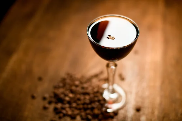 Alkoholbrun cocktail i glaset stående på träbordet med kaffebönor — Stockfoto