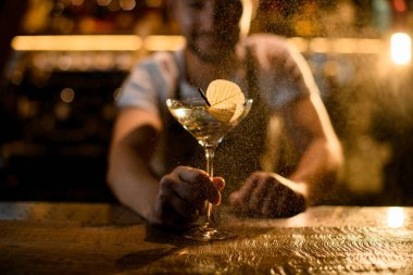 Barmen içkiye kuru yaprak takıyor.