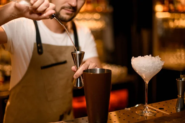 Бармен п'є коктейль з барною ложкою і цигаркою — стокове фото