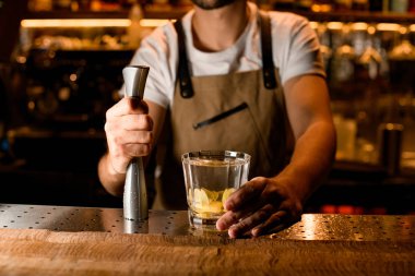 Barmen elinde ezici ve limonlu kokteyl tutuyor.