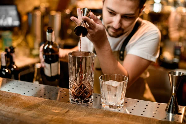 Barman nalewa alkohol z jiggera do szklanki — Zdjęcie stockowe