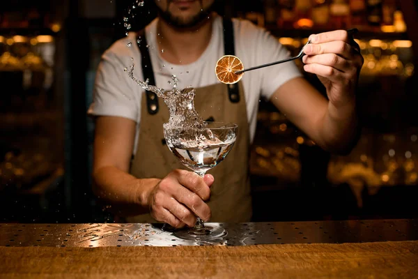 Gros plan de barman décorant éclaboussures d'alcool avec de l'orange — Photo