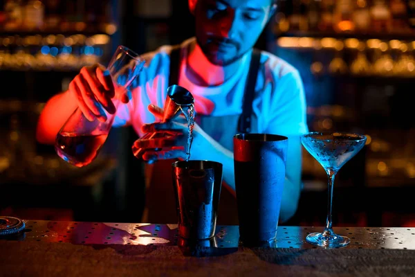 Бармен п'є коктейль з цигаркою в неонових вогнях — стокове фото