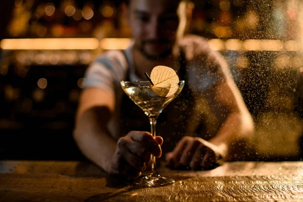 Barman servant un cocktail dans le verre orné d'une feuille séchée sur l'épingle — Photo