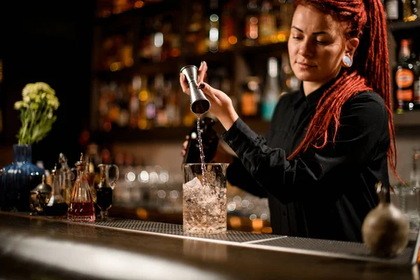 Bartender flui álcool de garrafa com jigger — Fotografia de Stock