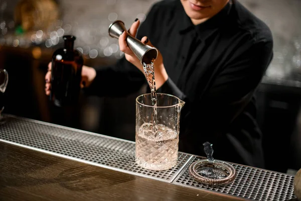 Barman derrama bebida de jigger para vidro — Fotografia de Stock