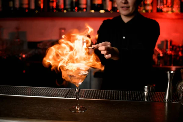 Bartender firing up alcohol cocktail on counter — Stock Photo, Image