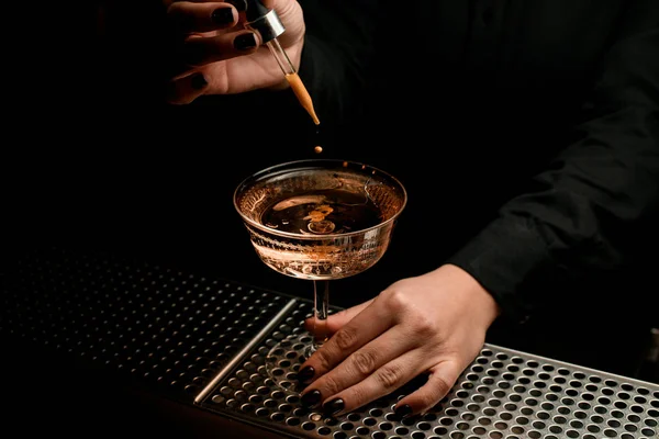 Barista professionista che fa una goccia di amaro dalla pipetta al cocktail nel bicchiere — Foto Stock