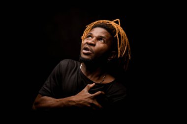 Afro-Amerikalı adam kendini göğsünden tutuyor.