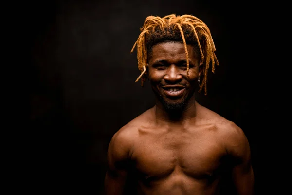 Sorrindo nu preto cara com dreadlocks loira posando no estúdio olhando para a câmera — Fotografia de Stock