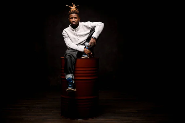 Afro-americano sentado em um barril — Fotografia de Stock
