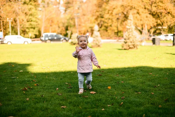 Sorrindo menina de pé no parque de outono no tempo quente — Fotografia de Stock