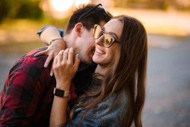 Mutlu romantik çift, sonbahar parkında sarılıyor.