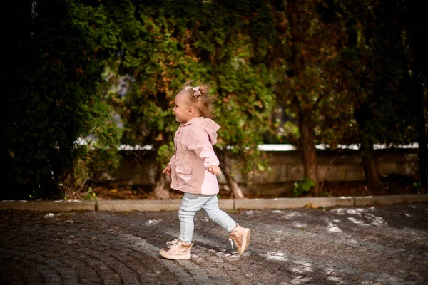 Senyum gadis kecil berjalan di taman di batu paving — Stok Foto