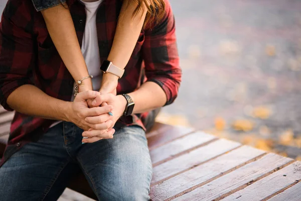 Homem sentado no banco no parque de outono e sua mulher abraçando-o — Fotografia de Stock