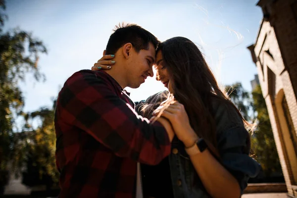 Happy man holding his woman on the face and looking into her eyes in the park — Stock Photo, Image