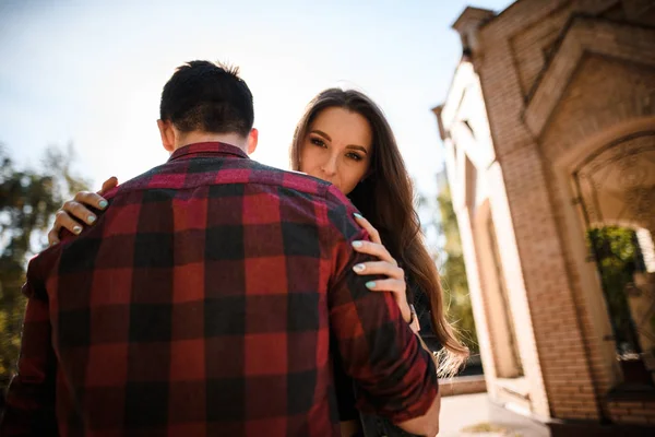 Woman looking over her husband s shoulder in the autumn park — Stock Photo, Image