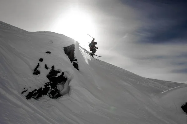 Narciarz skacze z klifu na nartach — Zdjęcie stockowe