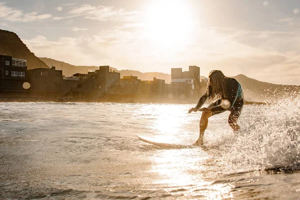 Homme en costume de plongée noir avec dreadlocks debout sur le surf — Photo