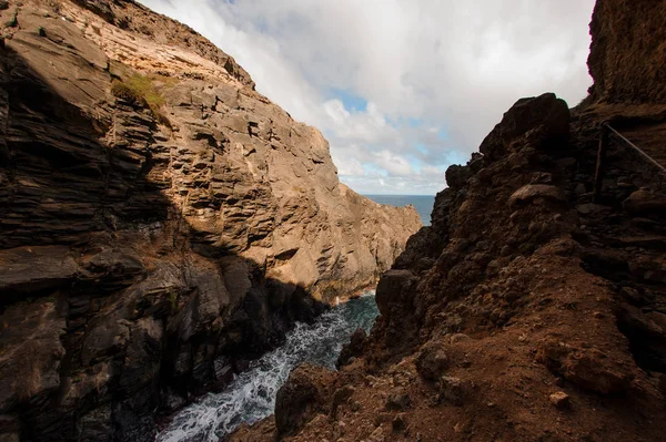 Vackert landskap flyter en liten flod ut i havet mellan två stora klippor — Stockfoto