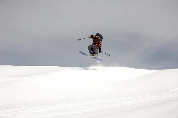 Skier jumps in the air while sliding down — Stock Photo, Image