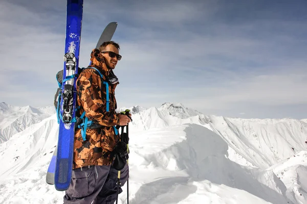 Homem com esqui e outros suportes de equipamento — Fotografia de Stock