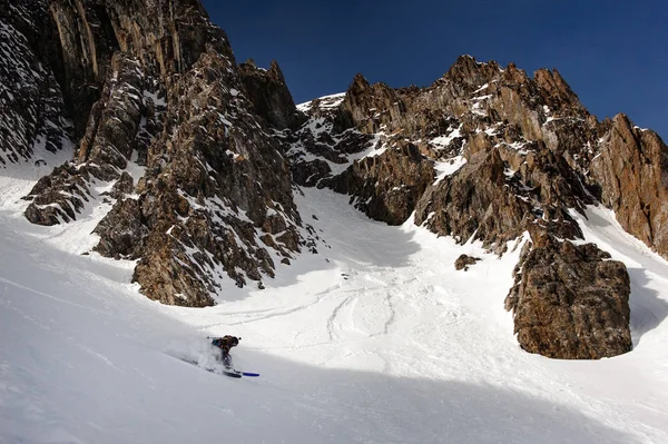 Vista de snowboarder deslizando para baixo do lado da montanha — Fotografia de Stock