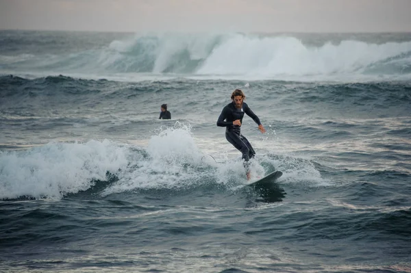 Mann mit Bart reitet Wellen auf Surfbrett — Stockfoto
