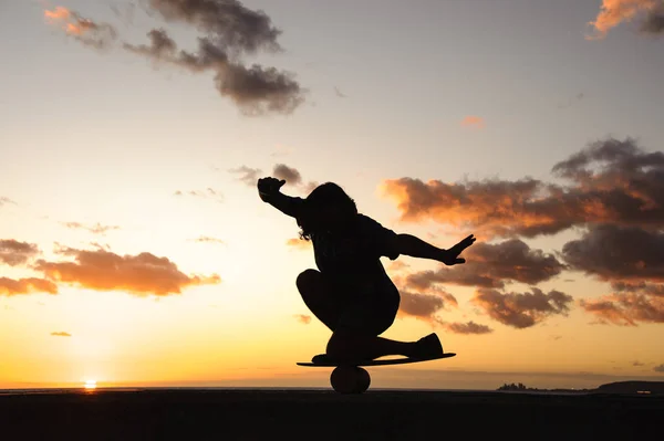 Silhouet van een man die balanceert op een balance board — Stockfoto