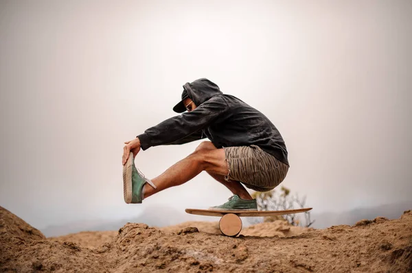 Guy with balance board on the mountain