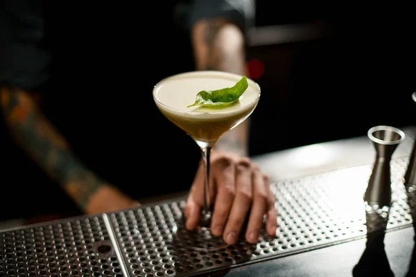 Primo piano di cocktail in bicchiere di martini in mano di baristi — Foto Stock