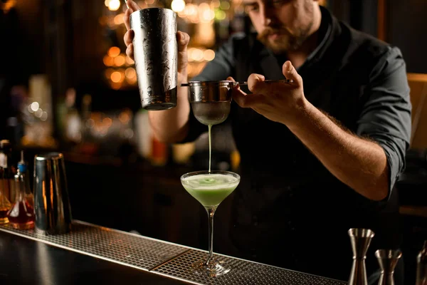 Barman filtruje alkoholický nápoj přes síto — Stock fotografie