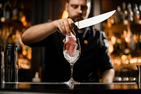 Barman met des morceaux de glace coupés dans le verre — Photo