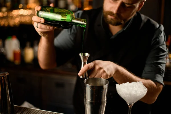 Barman przepływa alkohol z butelki do jiggera — Zdjęcie stockowe