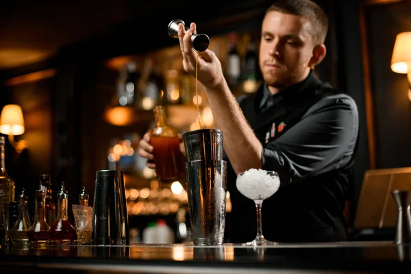 Barman stromende drank van jigger naar shaker — Stockfoto