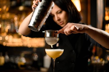 Barmen elek ile kokteyl hazırlar.