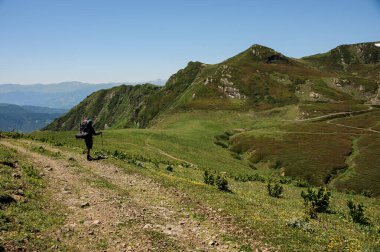 Yolcu tepelerde yolun kenarında duruyor.