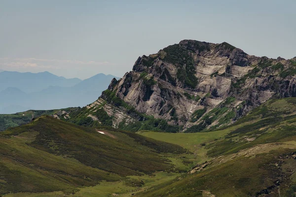 Vista para a montanha entre colinas verdes — Fotografia de Stock