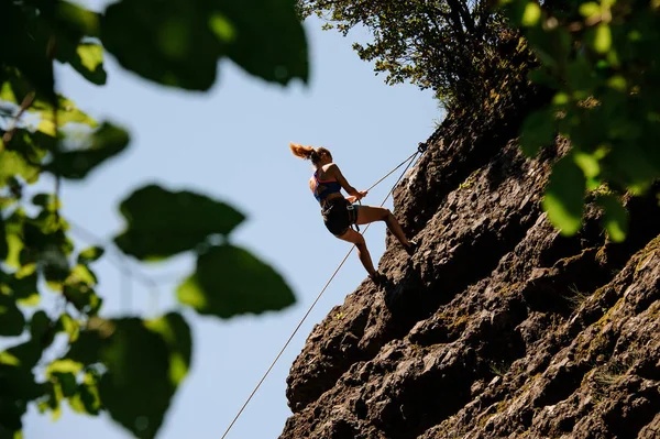 Vrouwelijke klimmer springt van de klif af — Stockfoto