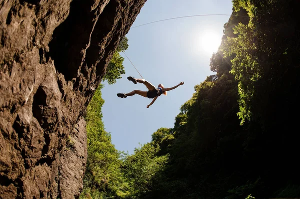 下から飛び跳ねる女性登山家のショット — ストック写真