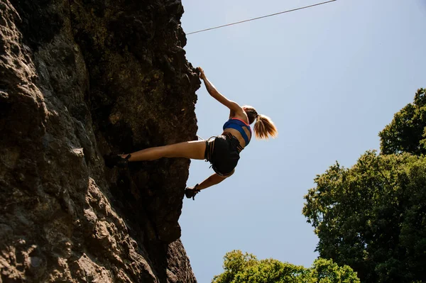 Sportliches Mädchen klettert an der steilen Felswand — Stockfoto