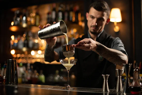 Чоловік бармен готує алкогольний коктейль з ситом — стокове фото