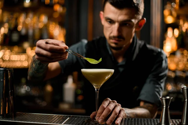 Barman met une petite feuille sur un cocktail — Photo